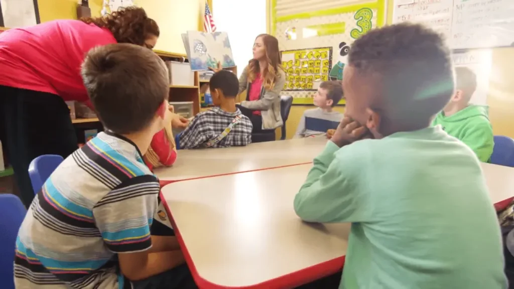 Teachers lead a story time for a group of young students, representing a focus on social and academic development.