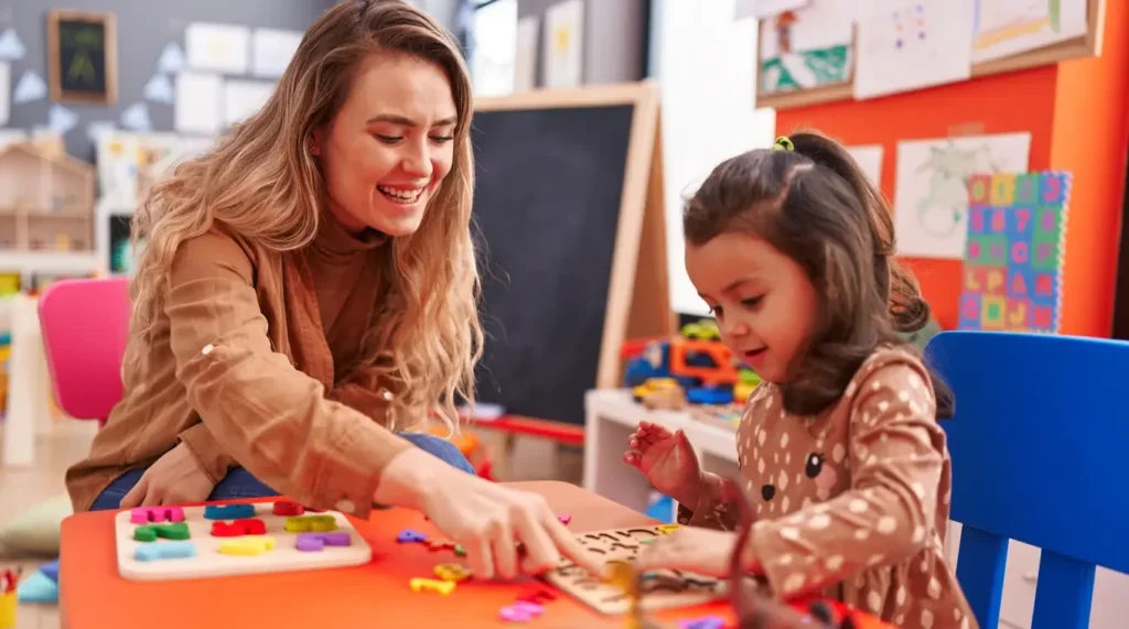 Recognizing Signs Your Child May Need Behavioral Therapy 1 teacher toddler playing with maths puzzle game sitting table kindergarten