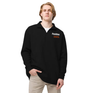 A person models a black quarter-zip pullover, a professional apparel item, featuring the embroidered Positive Leaps logo.