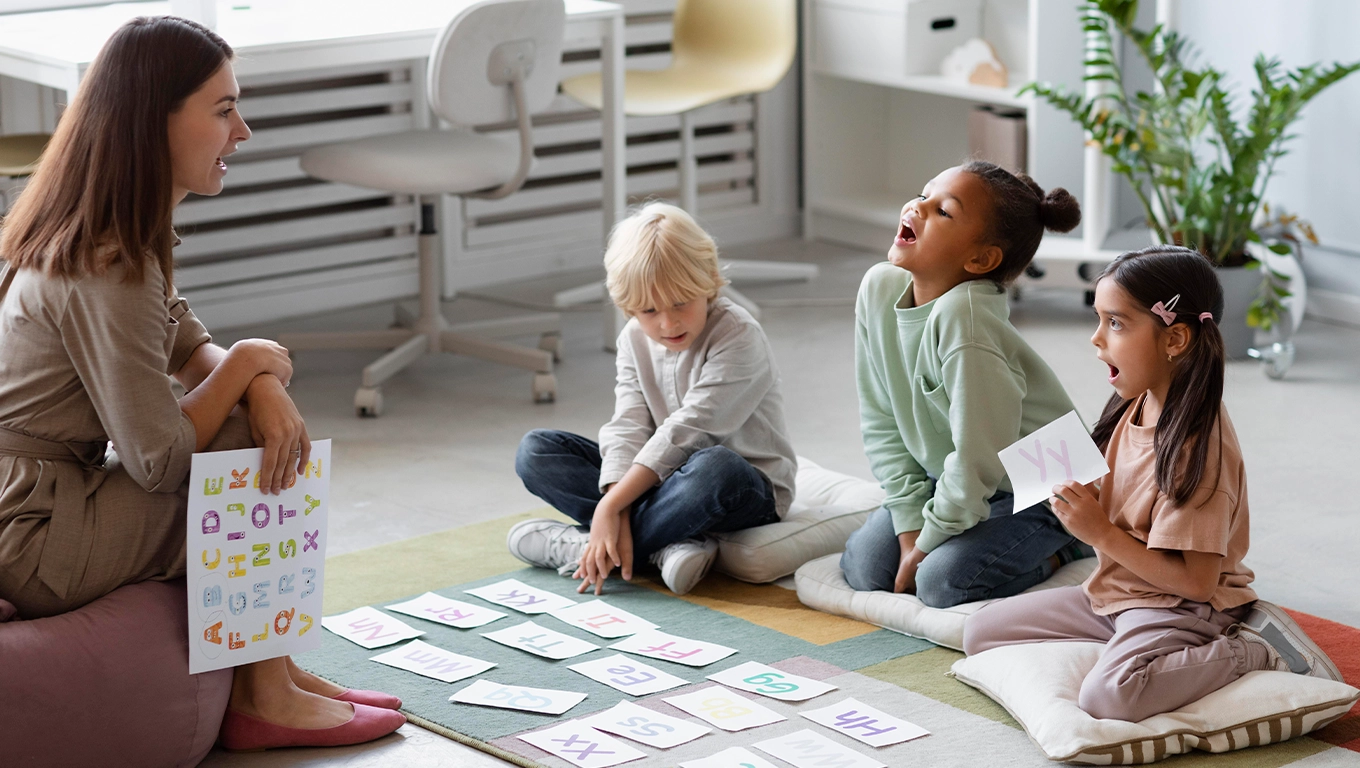 Therapy for an Aggressive Child: Helping Young Children Manage Big Emotions 1 Child therapist engaging with three young children during a supportive and playful group counseling session.